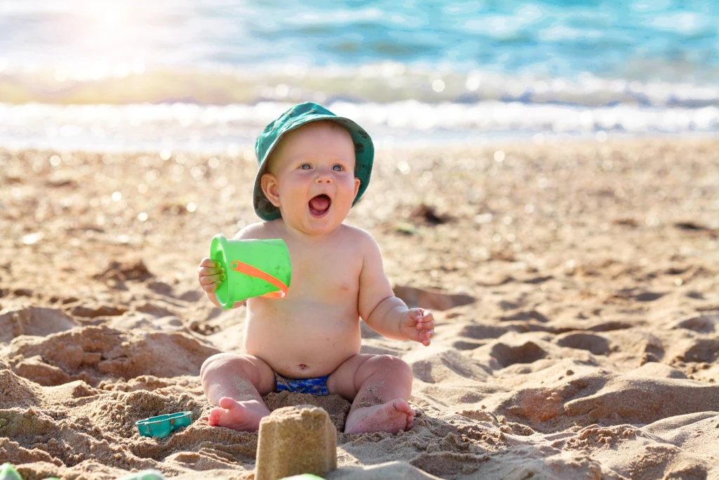 Dziecko na plaży buduje z piasku